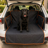 Black labrador sitting on waterproof car trunk mat, orange edge